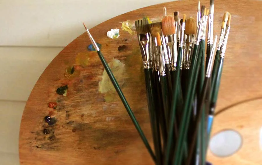 Nicholas's Painting Palette and Tools for Oil Portraits Nicholas’s well-used paint palette and a collection of brushes, showcasing the tools essential for his detailed oil pet portraits.